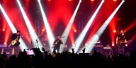 Rockmusiker auf der Bühne, in rotes Licht getaucht
