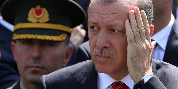 Recep Tayyip Erdogan fasst sich mit der Hand ins Gesicht