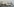 Ein Kreuzfahrtschiff hat an einem Landeplatz festgemacht, im Hintergrund die Skyline Hamburgs