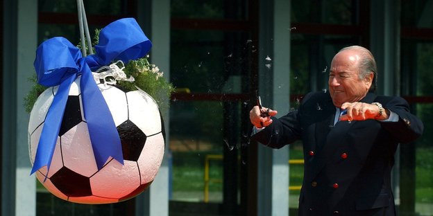 Fifa-Präsident freut sich über einen großen Fußball mit Schleife