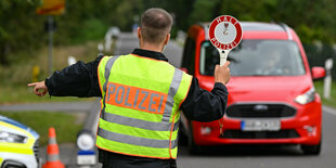 Ein Polizeibeamter stoppt ein Auto bei einer Kontrolle gegen Schleuserkriminalität