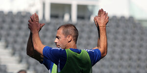 Uefa-Präsident Ceferin klatscht sich auf dem Fußballfeld mit einem Mitspieler ab