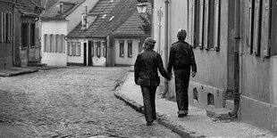 Ein junges Paar geht händchenhaltend durch die Stadt