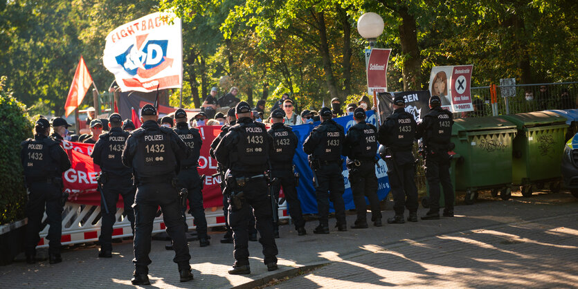 Eine Polizeikette steht vor einer Menge an Demonstrant*innen