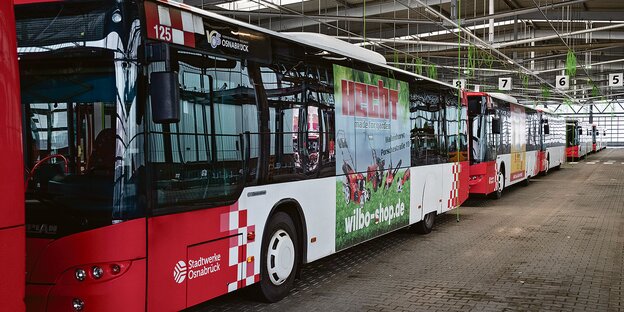 Busse der Osnabrücker Stadtwerke stehen in einer Halle.