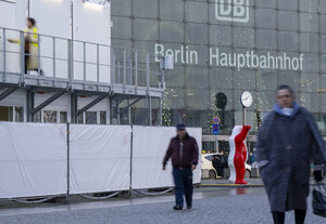 Menschen laufen an einem Container vor dem Berliner Hauptbahnhof vorbei.