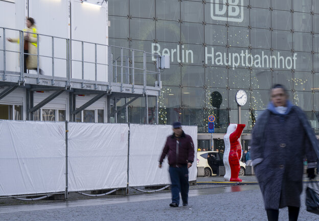 Menschen laufen an einem Container vor dem Berliner Hauptbahnhof vorbei.