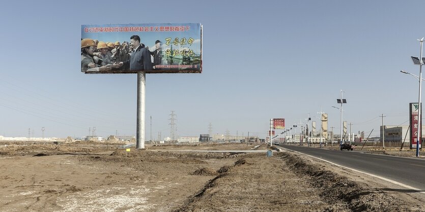 Ein Plakat mit dem Foto von Xi Jinping in einem Industriegebiet in China