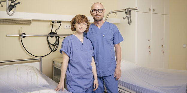 Eine Krankenpflegerin und ein Krankenpfleger stehen in einem Krankenhauszimmer