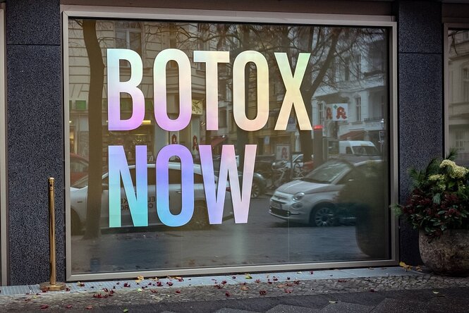 Eine Schaufensterscheibe, darauf sind die Worte "Botox Now" geklebt