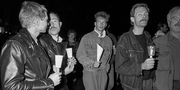 Männer demonstrieren mit Kerzen, Schwarz-Weiß-Aufnahme