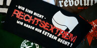 Ein T-Shirt mit der Aufschrift "Wir sind nicht rechtsextrem wir haben nur extrem Recht!" liegt auf einem Stapel rechtsextremer Mottoshirts.