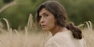 Die Schauspielerin Janet Novás schaut in ihrer Filmrolle als Hebamme Maria sorgenvoll aus einem Kornfeld