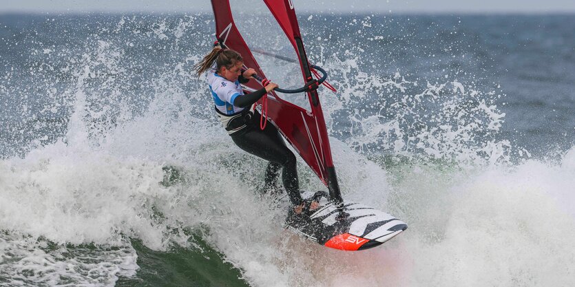 Eine Windsurferin reitet eine Welle