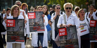 Ärzt*innen protestieren in Berlin mit Schilderrn "Praxis in Not"