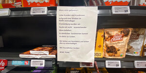 Zettel an Regal in einem Lebensmittelladen, auf dem steht, dass wegen des Streiks in einem Zentrallager nicht ausreichend Waren geliefert worden sind