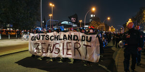 Demonstrant*innen hinter dem Hamburger Hauptbahnhof mit einem Plakat, auf dem "zensiert" steht