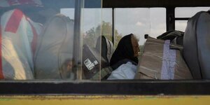 Eine ältere Frau sitzt einem Bus, der Flüchtende aus Bergkarabach nach Armenien bringt
