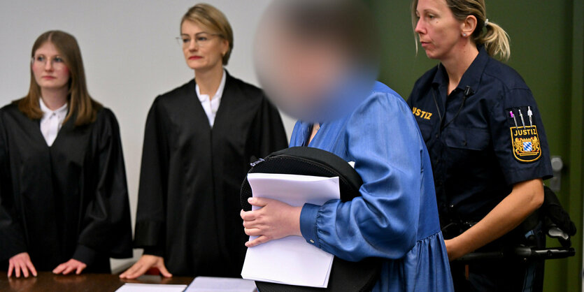 Die Angeklagte Andrea Tandler wird zu Prozessbeginn von einer Justizbeamtin neben ihren Anwältinnen in den Verhandlungssaal geführt