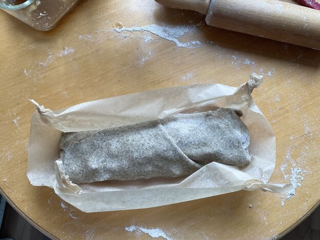 Ein noch ungebackener Apfelstrudel auf Backpapier
