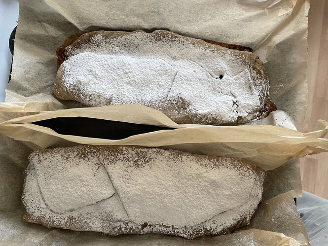 Zwei mit Puderzucker bestäubte Apfelstrudel auf dem Backblech