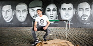 Cetin Gültekin, Bruder des Opfers Gökhan Gültekin, sitzt vor Porträts von Opfern des Anschlags