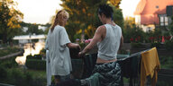 Ein queeres Paar hängt zuhause zusammen Wäsche auf