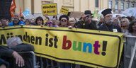 Teilnehmer*innen mit Banner und Schildern "München ist Bunt"