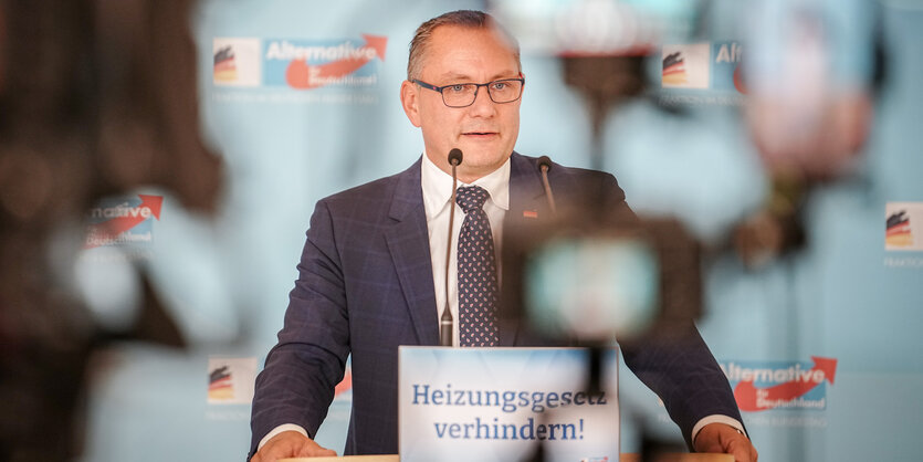 AfD-Chef Tino Chrupalla steht an einem Pult und spricht