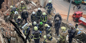 Rettungskräfte untersuchen die Trümmer eines Hauses