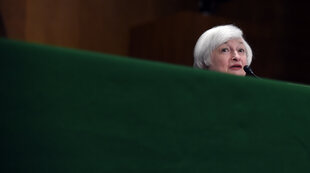 Janet Yellen hinter einem großen Pult am Mikrofon