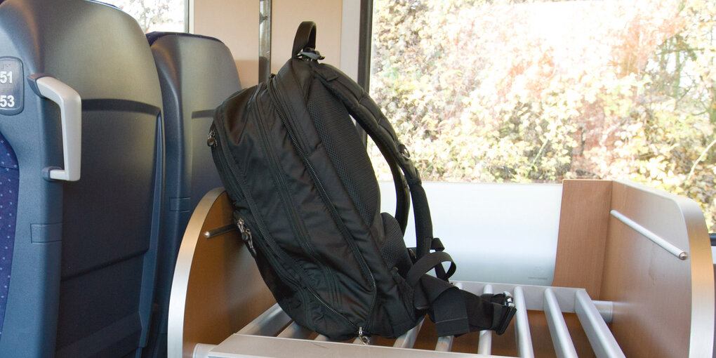 Eine Rucksack steht auf einer Gepäckablage in einem Zug