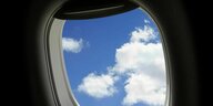 Blick aus einem Flugzeugfenster, zu sehen ist ein blauer Himmel mit weissen Wölkchen