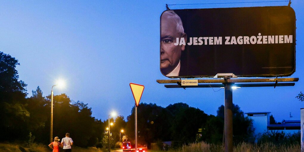 Nachtliche Stimmung in einem Vorort von Gliwice Polen. Sehr grosses Plakat mit dem angeschnittenen Porträt von Jaroslaw Kaczynski mit dem Slogan: ?Ich bin eine Bedrohung?