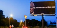 Nachtliche Stimmung in einem Vorort von Gliwice Polen. Sehr grosses Plakat mit dem angeschnittenen Porträt von Jaroslaw Kaczynski mit dem Slogan: ?Ich bin eine Bedrohung?