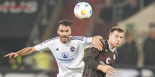 Zwei Fußballer springen zum Kopfball hoch