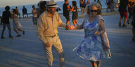 Ein älteres Paar tanzt am Meer