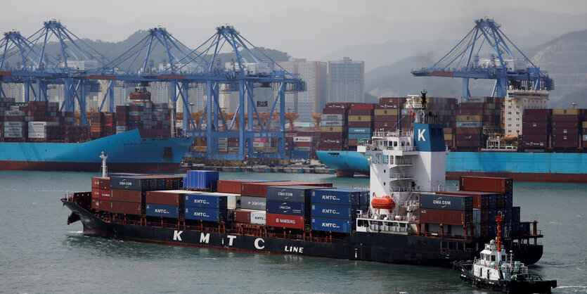 Ein beladenes Containerschiff vor einem Hafen