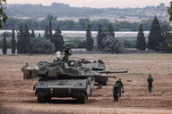 Israelische Soldaten auf und neben einem Panzer nahe des Gazastreifens