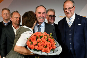 Frau mit rotem Blumenstrauß küsst Mann