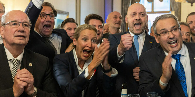 AfD Politiker:innen jubeln bei einer Wahlveranstaltung.