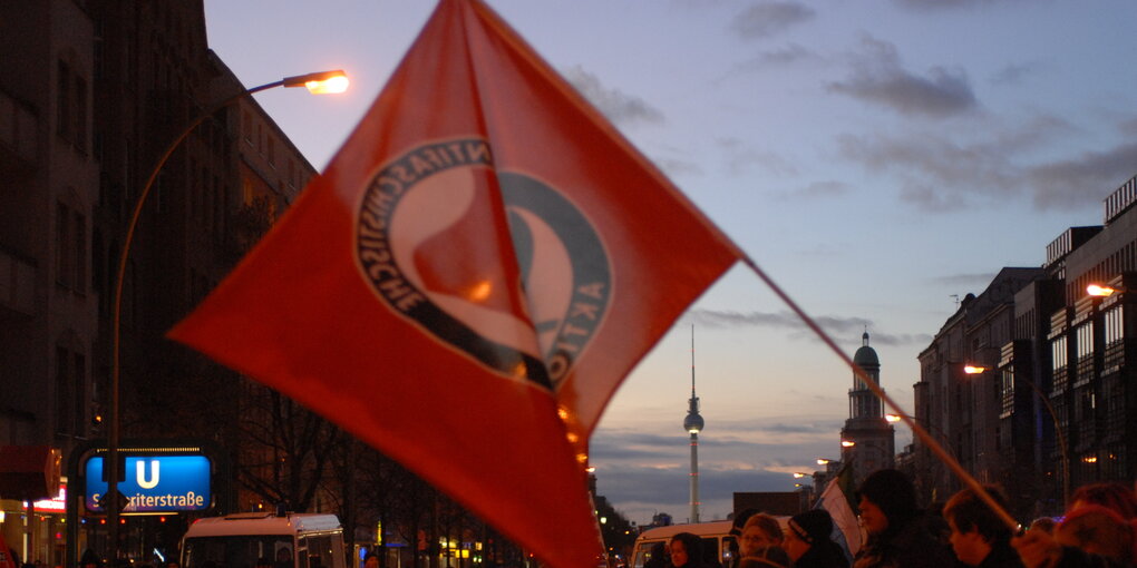 Eine Antifa-Fahne weht im Abendhimmel Berlins. Silvio Meier Gedenkdemonstration, die 2007 zum 15. Todestag durch Friedrichshain. Meier wurde 1992 von Neonazis getötet.