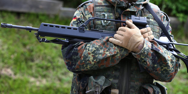 Soldat hält ein Sturmgewehr der Firma Heckler und Koch in den Armen