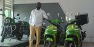 Mann steht vor neuen grünen E-Motorrädern