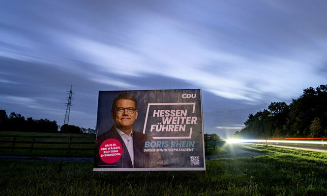 Auf einem Feld am Frankfurter Stadtrand steht ein Wahlplakat mit Hessens Ministerpräsident Boris Rhein: Hessen Weiter Führen ist sein Slogan