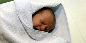 Ein Baby in einem Handtuch.