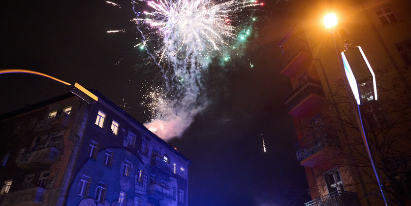 In der Rigaer Straße zünden Menschen Pyrotechnik von einem Haus.