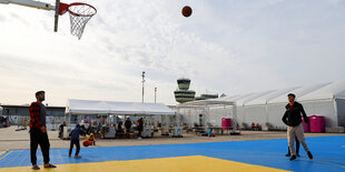 Geflüchtete auf dem Basketballfeld des Ankunftszentrums Tegel