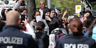 Polizist*innen von hinten, vor ihnen stehen Teilnehmer*innen einer verbotenen Kundgebung