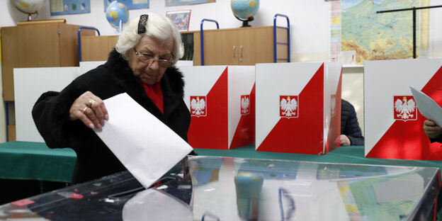 Ein Wähler steckt seinen Wahlzettel in die Wahlurne am 13. Oktober 2019 in Warschau